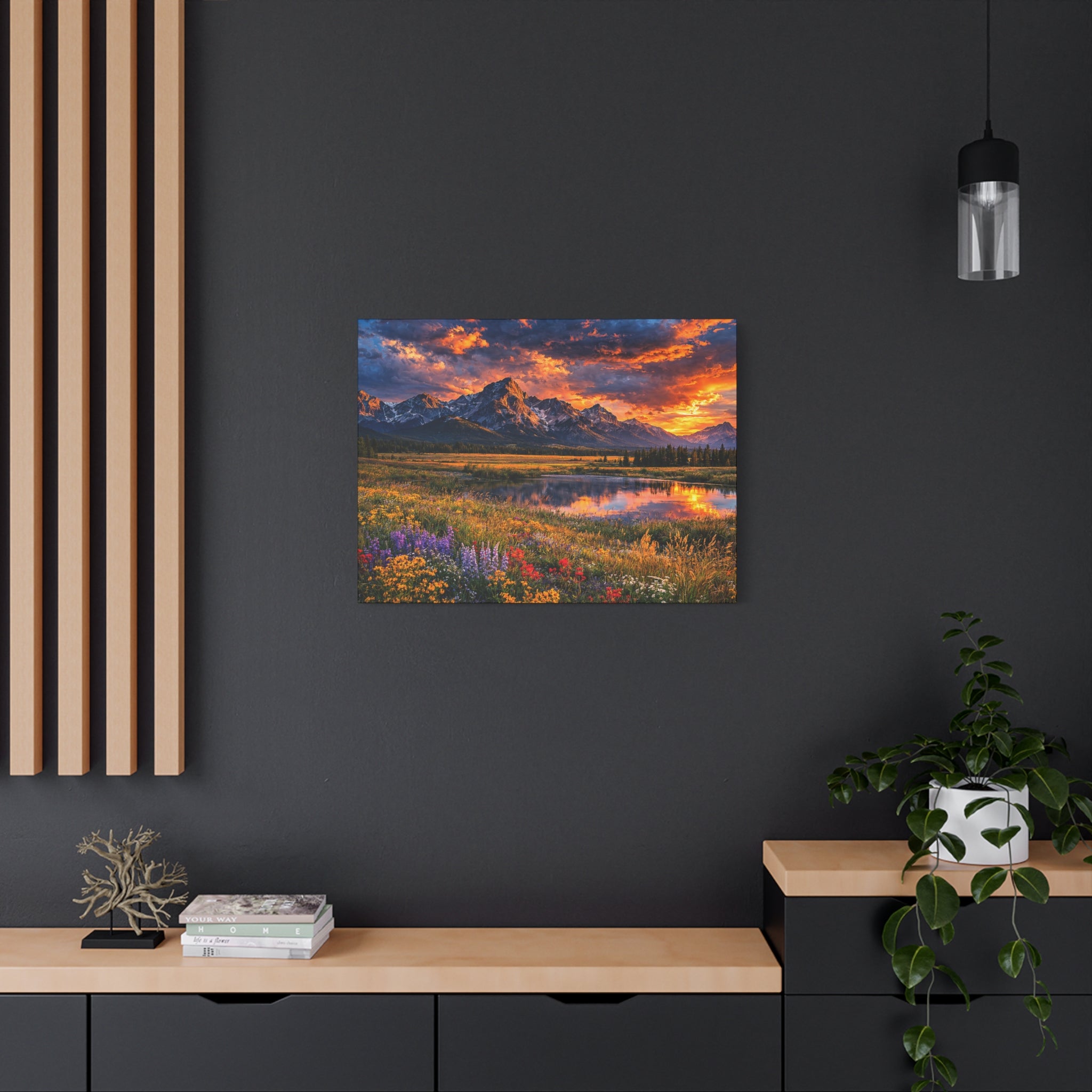 Painting of a mountain landscape with a colorful sunset on a dark wall.